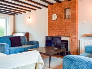 埃文河畔斯特拉特福Sidelands Sojourn的客厅配有蓝色椅子和壁炉