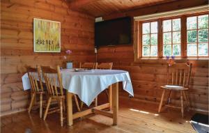 BakkegårdeNice Home In Jgerspris With Wifi的小屋内带桌椅的用餐室