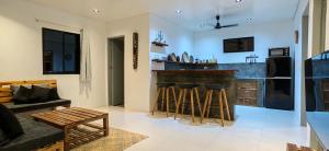 爱妮岛Calao Villa, Solar Villa 2 rooms with Private Pool的厨房设有带凳子和沙发的酒吧