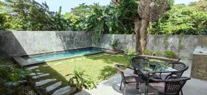 爱妮岛Calao Villa, Solar Villa 2 rooms with Private Pool的后院设有游泳池、桌子和椅子