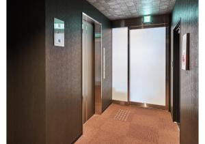 京都HOTEL LEGASTA KYOTO SHIRAKAWA SANJO的大楼内带开放式门的走廊