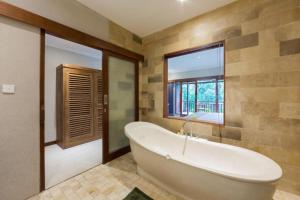 乌布乌布阿拉姆迪尼酒店的带浴缸和窗户的大浴室