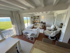 滨海布洛涅SERENITY VIEW Villa face mer aux magnifiques couchers de soleil的客厅配有白色家具和大窗户
