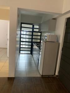 内罗毕Oasis comfort的带冰箱的厨房和通往客房的门