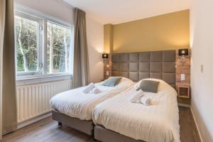 登霍伦Appartementen Bos en Duin Texel的一间卧室设有一张大床和一个大窗户