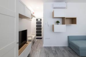 埃格尔Roomstore Studio Apartments的一间小公寓,拥有白色的墙壁和蓝色的沙发