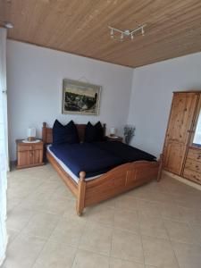 SolnhofenHaus zum Talblick的一间卧室配有一张带蓝色床单的床和木制天花板