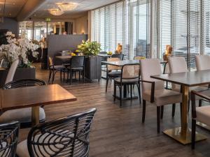爱德华Best Western Plus Hotel Restaurant Aduard的餐厅设有桌椅和窗户。