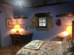 巴基奥Precioso caserío con jardín的一间卧室配有一张床、一张书桌和一个窗户。
