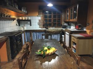 巴基奥Precioso caserío con jardín的厨房配有木桌,上面放着一碗水果