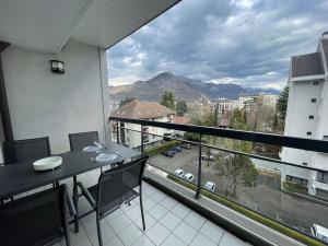 安锡Le Mont-Veyrier, parking et vue的阳台配有桌子,享有街道的景色