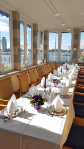 石勒苏益格斯坦德哈勒艾克森特酒店的一间长餐厅,配有白色的桌子和椅子