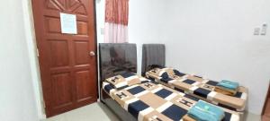 SeribuTaras Homestay的一间卧室设有两张床和棕色的门