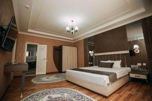 乌尔根奇FAYZ的一间卧室配有一张大床和一个吊灯。