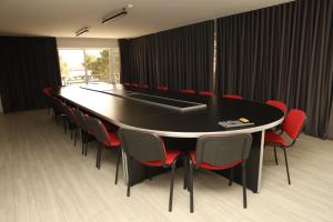 阿哈尔齐赫Aventus Hotel的一间会议室,配有黑桌子和红色椅子