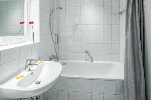 韦斯特兰Top Appartements Roth am Strande的白色的浴室设有水槽和浴缸。