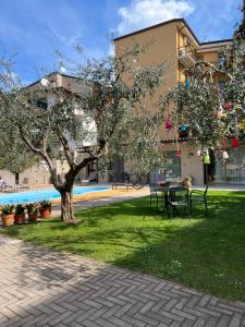 加尔达Appartamenti Villa Dall'Agnola的一座公园,在一座建筑前有桌子和树