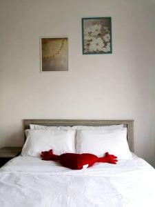 塞贝维KA701-One Bedroom Apartment- Wifi -Netflix -Parking - Pool, 1002的一只红泰迪熊躺在白色的床上