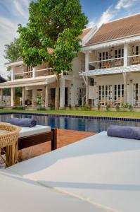 琅勃拉邦Chic stay HANA Boutique hotel的一座带游泳池的度假村,位于一座建筑前