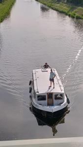 拉贝河畔罗乌德尼采Zouw Hausboat Zakotven -pouze ubytovaní的站在水中的船上的人
