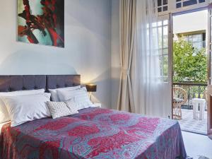 罗德镇Villa Sanyan - Adults Only的一间卧室配有一张带红色毯子的床和窗户。