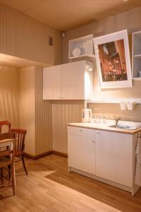 里加St.Jacobs's apartments Old Town Riga的厨房配有白色橱柜、水槽和桌子