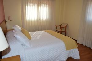 Antas de UllaHotel Restaurante Val的卧室配有一张大白色床和窗户