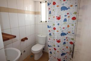 马约城Villa Sol e Mar - Vila do Maio - Ponta Preta的浴室设有卫生间和鱼缸淋浴帘