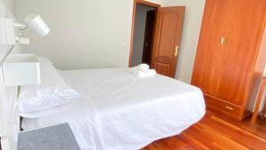 费雷拉Apartamentos Pantón Ribeira Sacra的卧室配有带灯和门的白色床