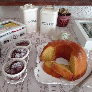 朱尔迪尼亚诺Gli Archi Country Home的一张桌子,上面放着蛋糕和两杯咖啡