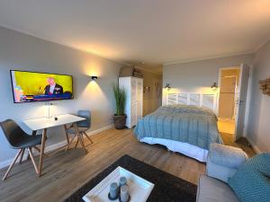 文尼斯塔特KNYD'S am MEER的一间卧室配有一张床、一张书桌和一台电视。