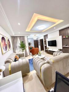 阿布贾Bee-City Homes的带沙发和平面电视的客厅