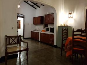 本托塔奇特拉阿育吠陀酒店的厨房配有木制橱柜和绿色冰箱。