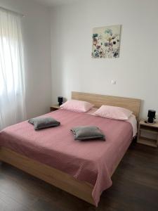 扎达尔Apartment Sanja的一间卧室配有一张大床和两个枕头