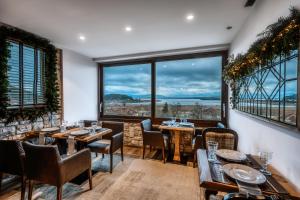 约阿尼纳MONTANA LAKE VIEW的餐厅设有桌椅和大窗户。