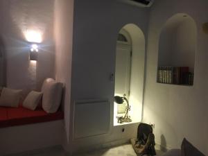 Sidi el MoujahedSuite Aurora Villa Naïa Domaine Béluga的一间设有红色长凳和灯的白色门的房间