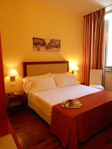 米兰米纳瓦酒店酒店的一间酒店客房,配有一张床铺和一张桌子,上面装有托盘