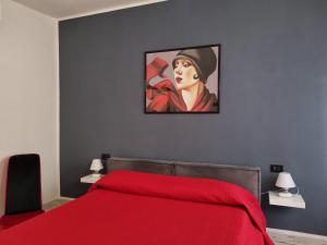 卡波利韦里Solino House的卧室配有红色的床和一幅女子画
