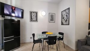 卡波利韦里Casa Iris的一间设有桌子的用餐室和墙上的电视