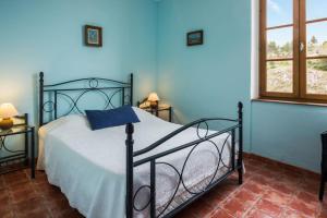 Portel-des-CorbièresLe Relais de Tamaroque的一间卧室配有一张蓝色墙壁的床