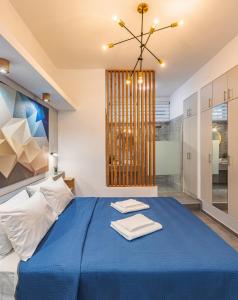 斯巴达Theo's Cozy Apartment near Athens airport的一间卧室配有蓝色的床和吊灯。