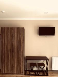 卡兹贝吉Hotel Gold Kazbegi的一间房间,墙上有桌子和电视