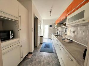 赫尔采格诺维Monteview Duplex的厨房配有白色橱柜和蓝色地毯。