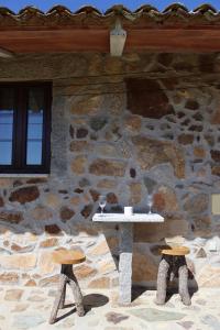 凡道Holiday Accommodation, Serra da Estrela - Casa Cabeço do Barragão的石头建筑,上面有酒杯桌子
