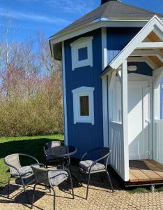 格林斯泰兹Kroghs Tiny Houses - Hyttebyen的前面带椅子和桌子的蓝色小棚