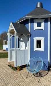 格林斯泰兹Kroghs Tiny Houses - Hyttebyen的蓝色的带蓝色椅子和长凳的棚屋