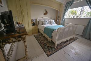 圣艾夫斯霍威尔旅舍的一间卧室配有一张床、一张书桌和一台电视