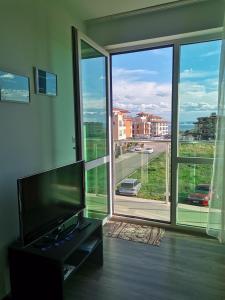 布尔加斯Clara Sea View的客厅配有平面电视和大窗户。