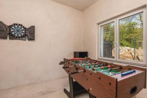 尤尔达尼Holiday home Brgud with private pool near Opatija的游戏室设有飞镖板和棋盘