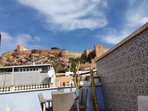 阿尔么丽亚Casa Azul de la Almedina de Almería的阳台配有椅子,享有城堡的景色